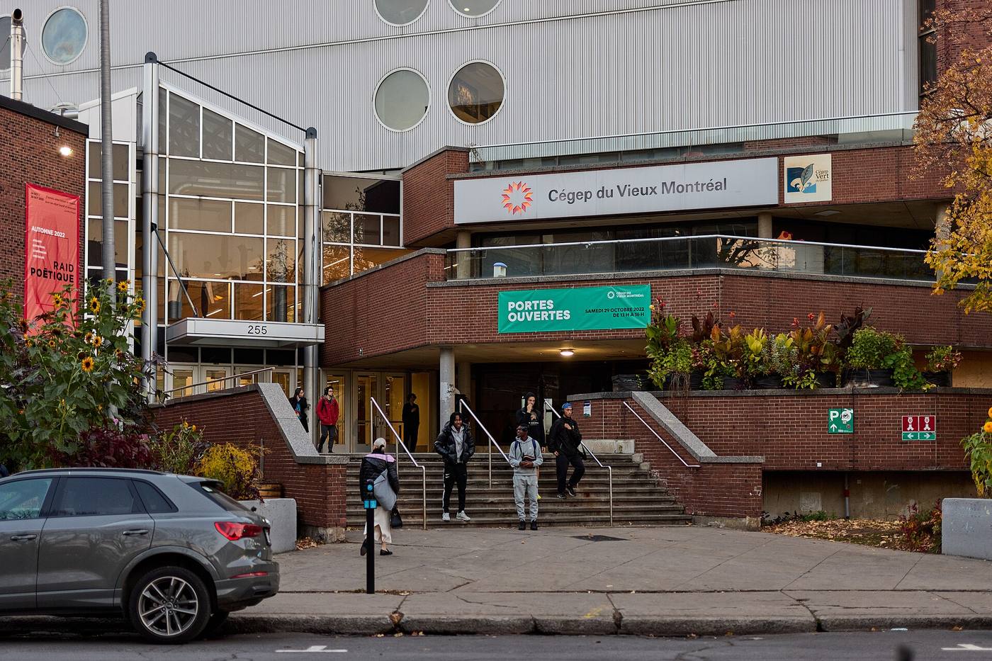 Кирпичное здание колледжа с вывеской Cégep du Vieux Montréal, студенты на ступенях